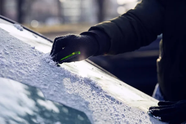 車のフロント ガラスの氷をこする人 — ストック写真