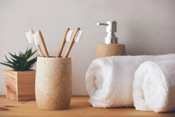 Four Bamboo Toothbrushes Cup White Towels — Stock Photo, Image