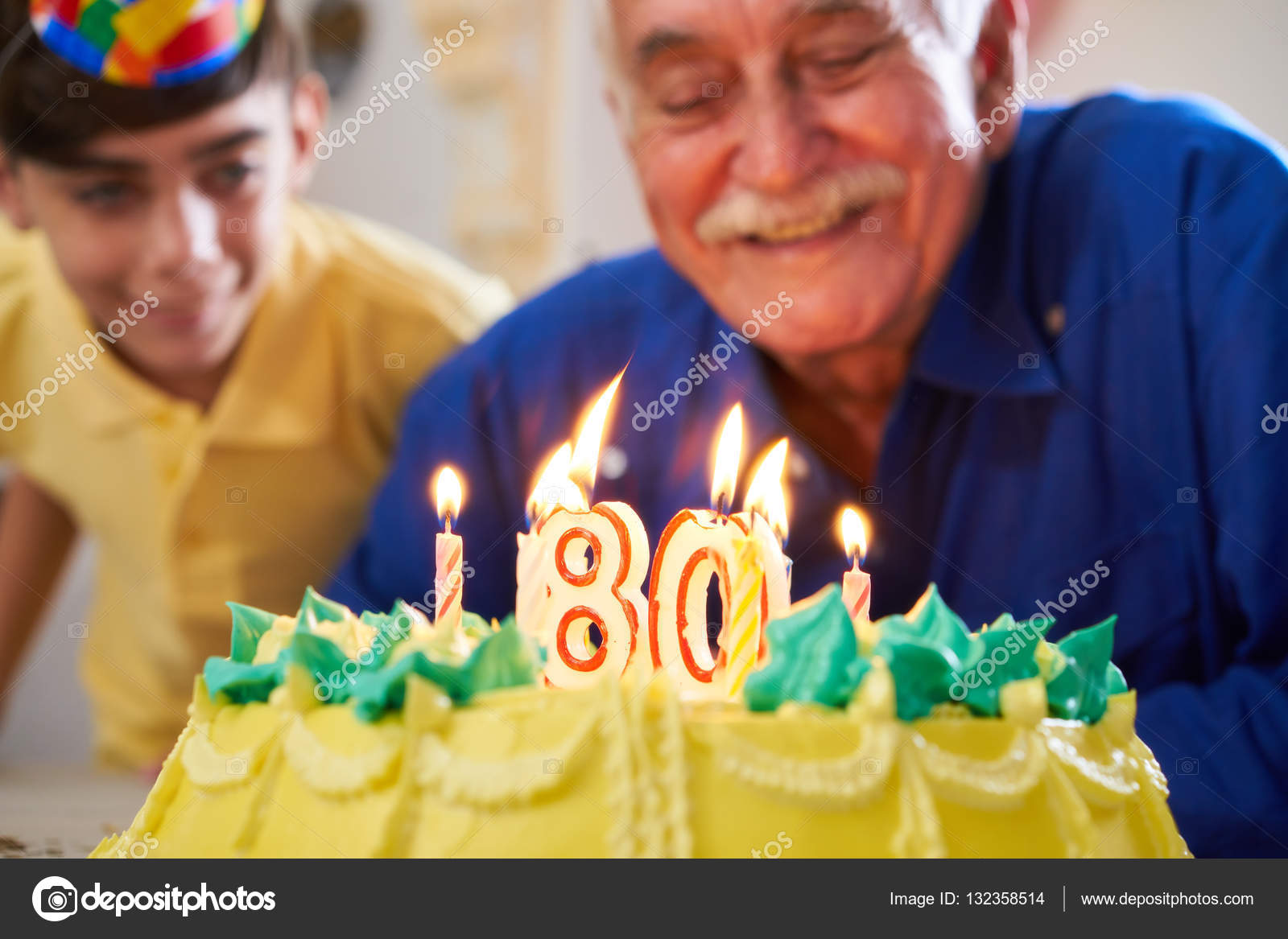 Close-up do homem adulto engraçado comemorando seu aniversário, segurando o  bolo bday com vela, soprando wistle festa e regozijando-se, em pé sobre  fundo azul claro.