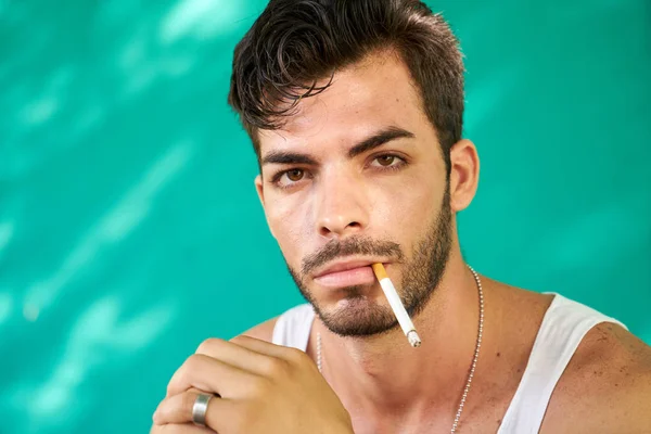 Muž kouří a při pohledu na fotoaparát — Stock fotografie