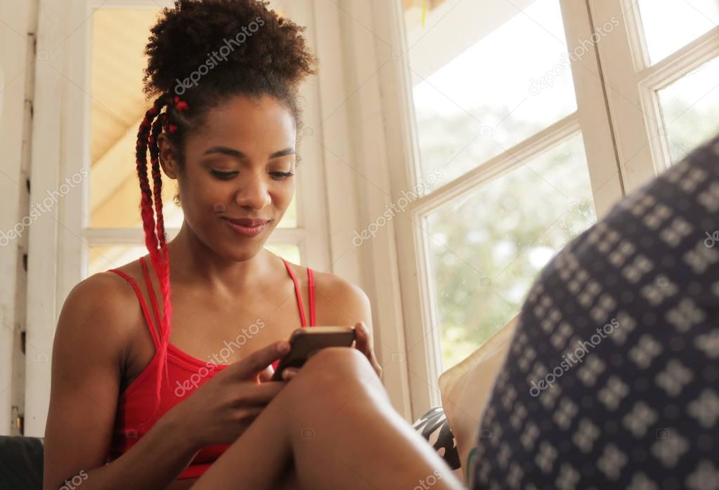 Young Black Woman Reading Phone Message And Smiling