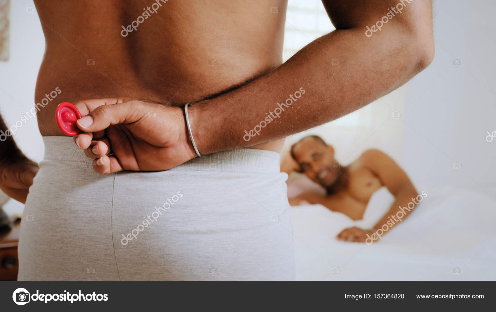 Gay People Using Condom For Safe Sex In Home Bed Stock Photo by ©diego_cervo 157364820