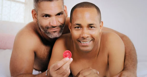Gay ζευγάρι ζευγάρι ομοφυλόφιλων ανδρών δείχνει προφυλακτικό για ασφαλές σεξ — Φωτογραφία Αρχείου