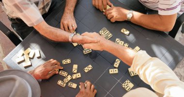 Senior Friends Shaking Hands Winning Game Of Domino clipart