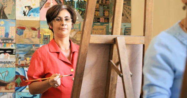 Porträtt av lycklig kvinna ler måleri vid Konstskolan — Stockfoto