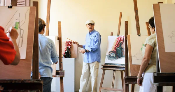 Δάσκαλος στην εργασία στο μάθημα της ζωγραφικής με τελειόφοιτους σπουδαστές — Φωτογραφία Αρχείου