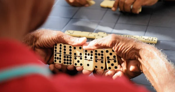 Černá v důchodu starší muž hraje Domino hru s přáteli — Stock fotografie