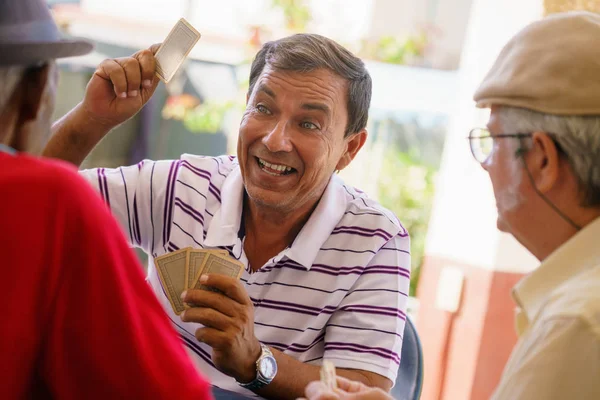 Gruppe glücklicher alter Freunde spielt Karten und lacht — Stockfoto