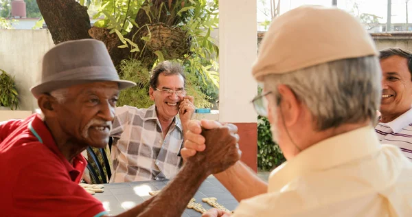 Gamla män skakar hand vinna spelet Domino — Stockfoto