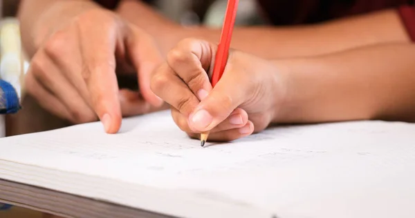 Elemental chica haciendo tarea escritura a mano en el libro de ejercicios —  Fotos de Stock