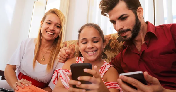 Família hispânica rindo jogando jogo no telefone Smartphone — Fotografia de Stock