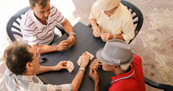 Grupp av ledande män spelkort spel i uteplats — Stockfoto