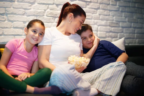 Alleinerziehende Mutter und Kinder schauen nachts fern — Stockfoto