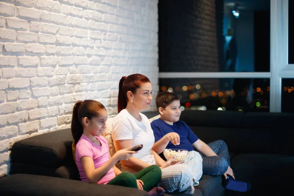 Ensamstående mor och barn titta på Tv på natten — Stockfoto