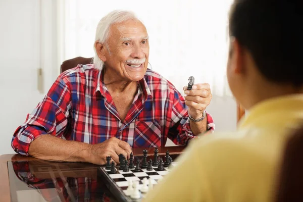 Abuelo jugando al Ajedrez Juego de mesa con su nieto en casa —  Fotos de Stock