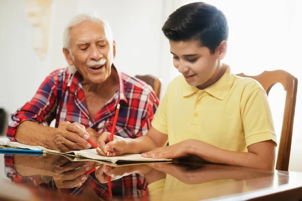 Ragazzino che fa i compiti a scuola con il vecchio a casa — Foto Stock