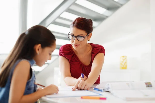 Educazione con mamma aiutare figlia fare scuola compiti a casa — Foto Stock