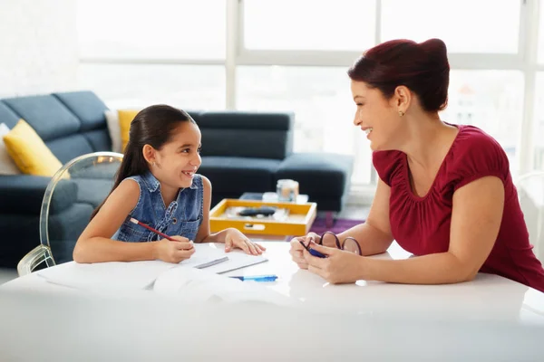 Educación con mamá ayudando a la hija a hacer la tarea de la escuela en casa — Foto de Stock