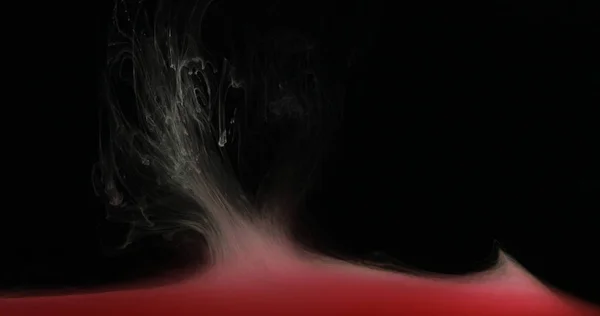 Peinture à l'encre rouge dans l'eau créant des formes artistiques liquides — Photo