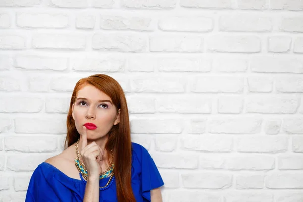 Genç Kızıl saçlı kadının tuğla duvar yüz ifadeleri — Stok fotoğraf