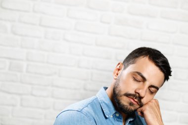 Genç sakallı adam tuğla duvar yüz ifadeleri