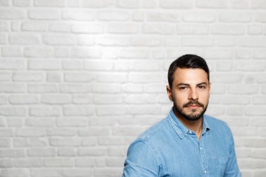 Genç sakallı adam tuğla duvar yüz ifadeleri