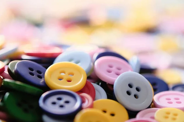 Большая группа разноцветных пластиковых кнопок для шитья на столе — стоковое фото