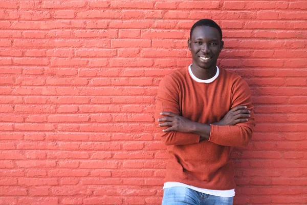 Africano joven sonriendo con rojo pared en fondo —  Fotos de Stock