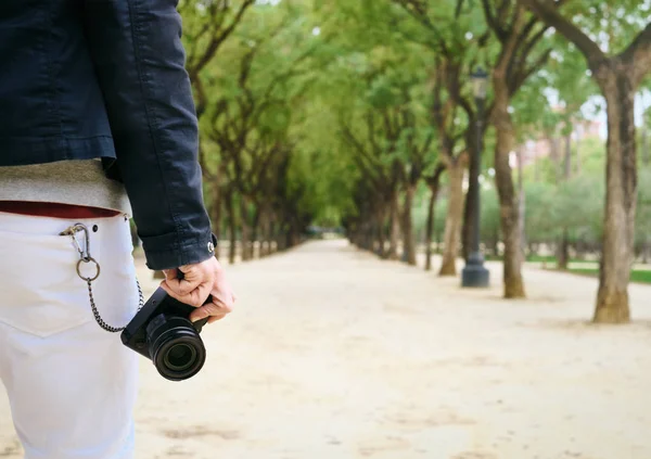 Hipster-Straßenfotograf läuft mit spiegelloser Kamera in der Hand — Stockfoto