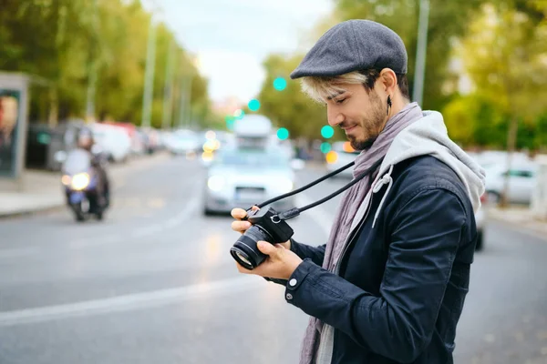 Hipster Street Fotógrafo Revisión de imágenes en la pantalla de la cámara sin espejo — Foto de Stock