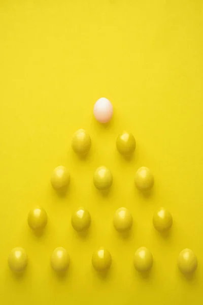 Pattern Of Chicken Eggs In Pyramid Shape Against Yellow Background — Stock Photo, Image