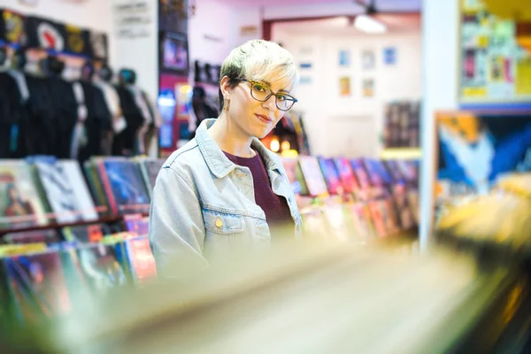 Молодая женщина выбрала винтажный винил LP в магазине Records — стоковое фото