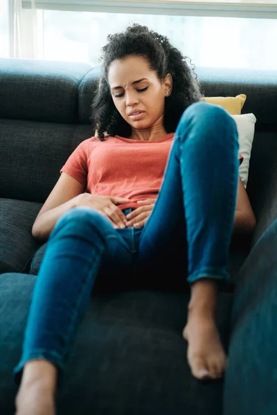 Young Black Woman With Menstrual Pain Lying On Sofa — Φωτογραφία Αρχείου