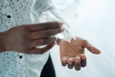 Afrika kökenli Amerikalı Kadın Cildini El Dezenfektanı ile Dezenfekte Ediyor