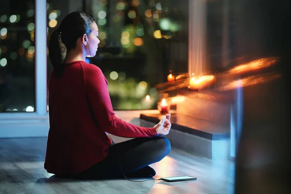 Mujer meditando en la noche con la aplicación del teléfono inteligente para el yoga — Foto de Stock