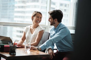 Şirket ofisinde dizüstü bilgisayarla birlikte çalışan iki kişi.