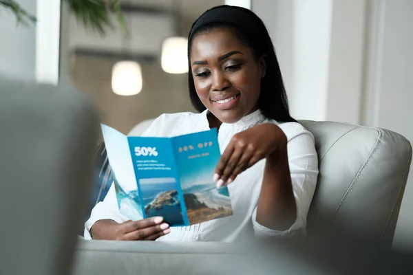 Black Woman Reading Travel Flyer For Holiday Trip — Stock fotografie