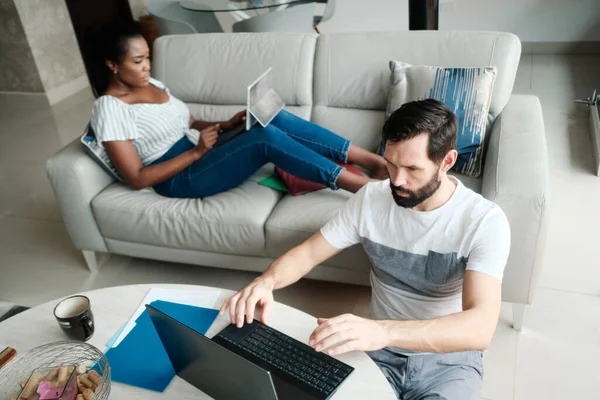 Пара працює і грає з ноутбуком комп'ютера вдома — стокове фото