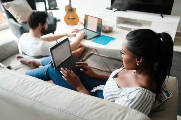 Pareja trabajando y jugando con el ordenador portátil en casa —  Fotos de Stock