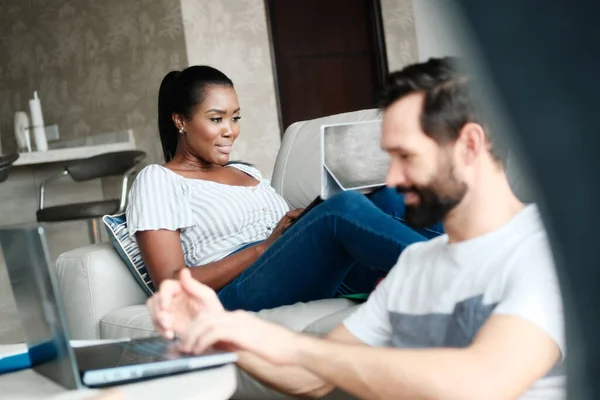 Casal trabalhando e jogando com computador portátil em casa — Fotografia de Stock