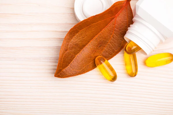 Alternativmedizin mit orangefarbenem Blatt und weißem Behälter — Stockfoto