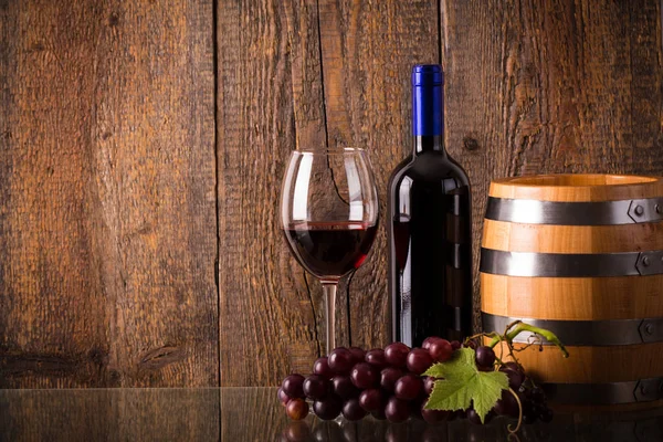 Pohár vörös bor, üveg üveg hordó szőlővel — Stock Fotó