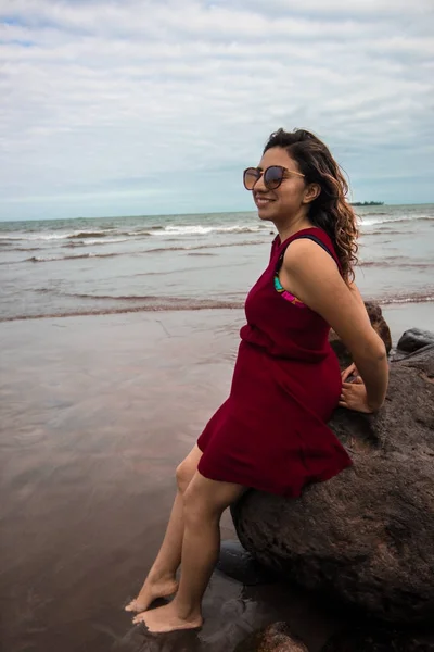 Chica sobre una roca en la playa — Foto de Stock