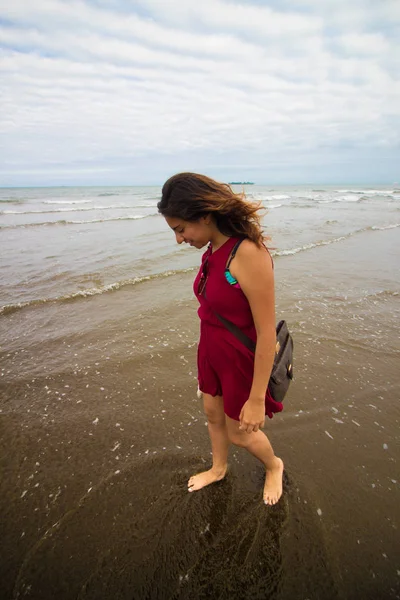 Chica observsus pies en la playa — Foto de Stock