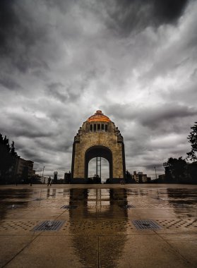 Un dia nublado como lienzo en blanco, esta listo para una pincelada de color. Las nubes rodean con mucha fuerza el gran monumento a la revolucion, mientras el reflejo del agua muestra su Belza arquitectonica.