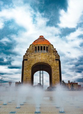 Un dia nublado como lienzo en blanco, esta listo para una pincelada de color. Las nubes rodean con mucha fuerza el gran monumento a la revolucion, mientras el reflejo del agua muestra su Belza arquitectonica.