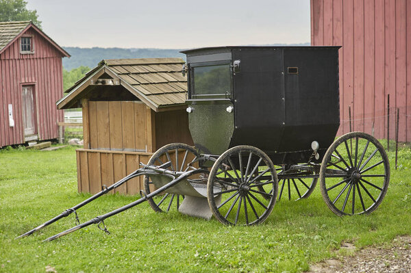 amish buggy parked next to barn