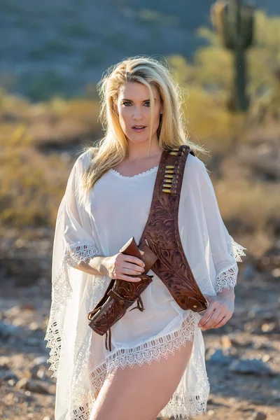 Modelo rubia en el desierto con pistola —  Fotos de Stock