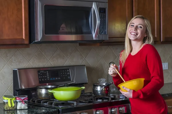 Genç sarışın kadın bir yemek pişirme