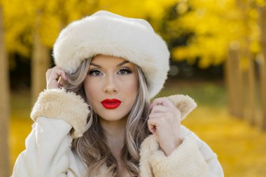 Güzel sarışın Model sarı yapraklar bir alana poz